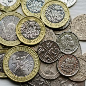 a pile of british coins sitting on top of a table